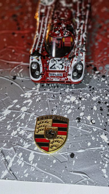 Rennwagen im Schnee mit dem Porsche-Wappen im Vordergrund.